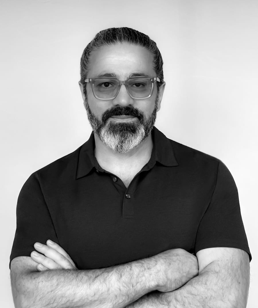 Portrait of director Soran Mardookhi, arms crossed, in black and white.