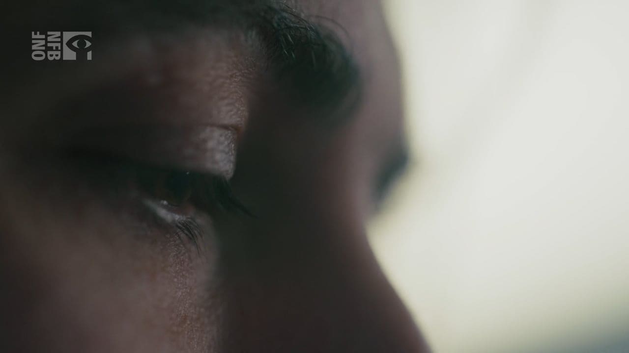 A close-up of a woman’s eyes as she looks toward a window.